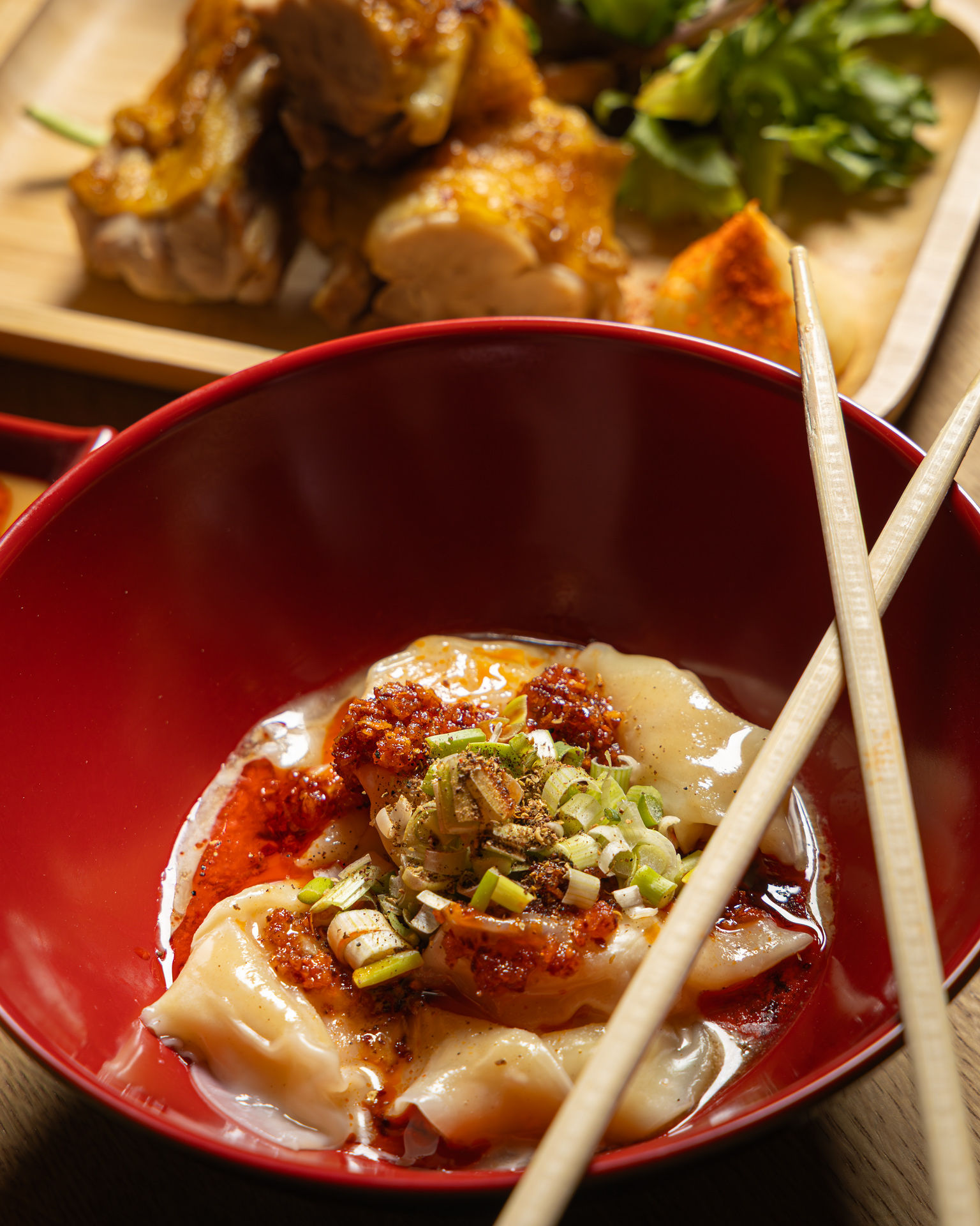 Overhead spread of Oodles dishes — chicken, edamame, kimchi, wakame and ramen